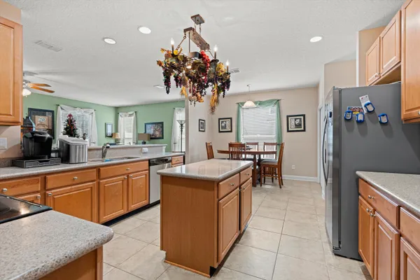 a kitchen with stainless steel appliances granite countertop a sink a counter top space and living room view