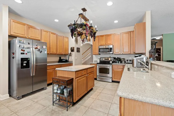 a kitchen with stainless steel appliances granite countertop a stove refrigerator and a sink