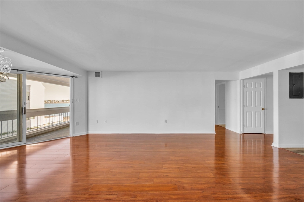 1 Commodore Court, Unit 202 Hull, MA 02045 - Photo 11 of 35 a view of an empty room with wooden floor and a window