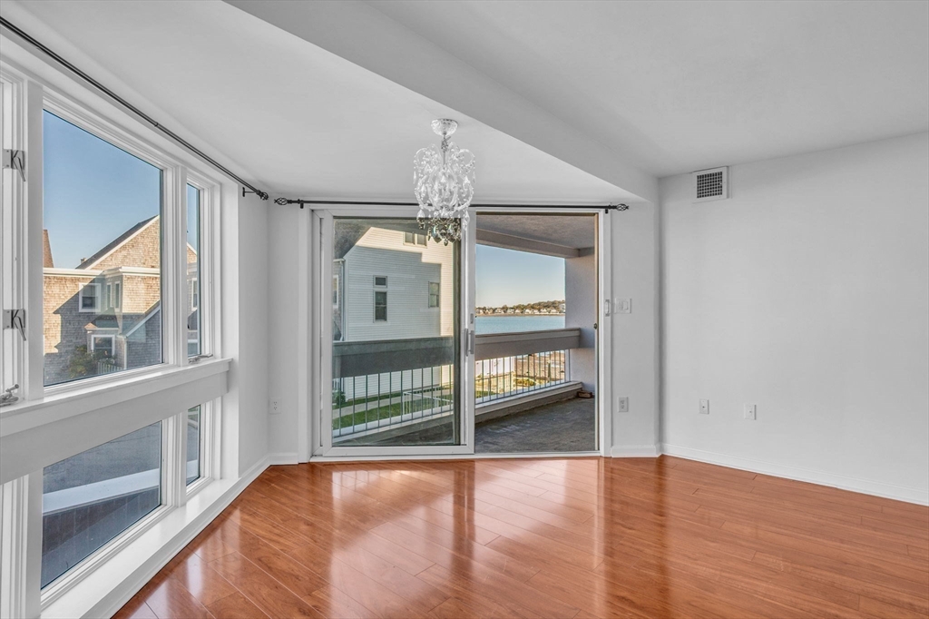1 Commodore Court, Unit 202 Hull, MA 02045 - Photo 12 of 35 a view of empty room with wooden floor and fan
