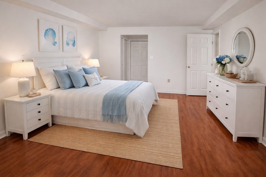 1 Commodore Court, Unit 202 Hull, MA 02045 - Photo 6 of 35 a spacious bedroom with a bed and a dresser