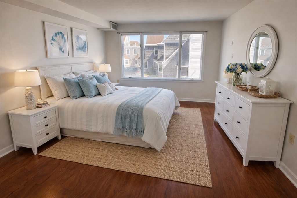 1 Commodore Court, Unit 202 Hull, MA 02045 - Photo 7 of 35 a spacious bedroom with a bed a dresser next to a window