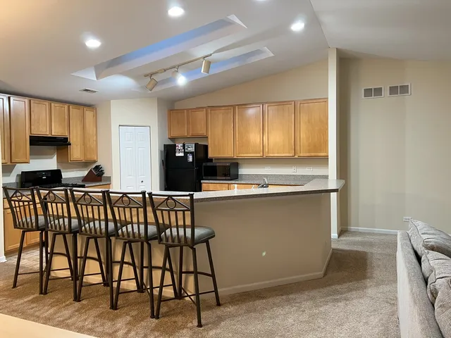 a kitchen with a table chairs refrigerator and cabinets