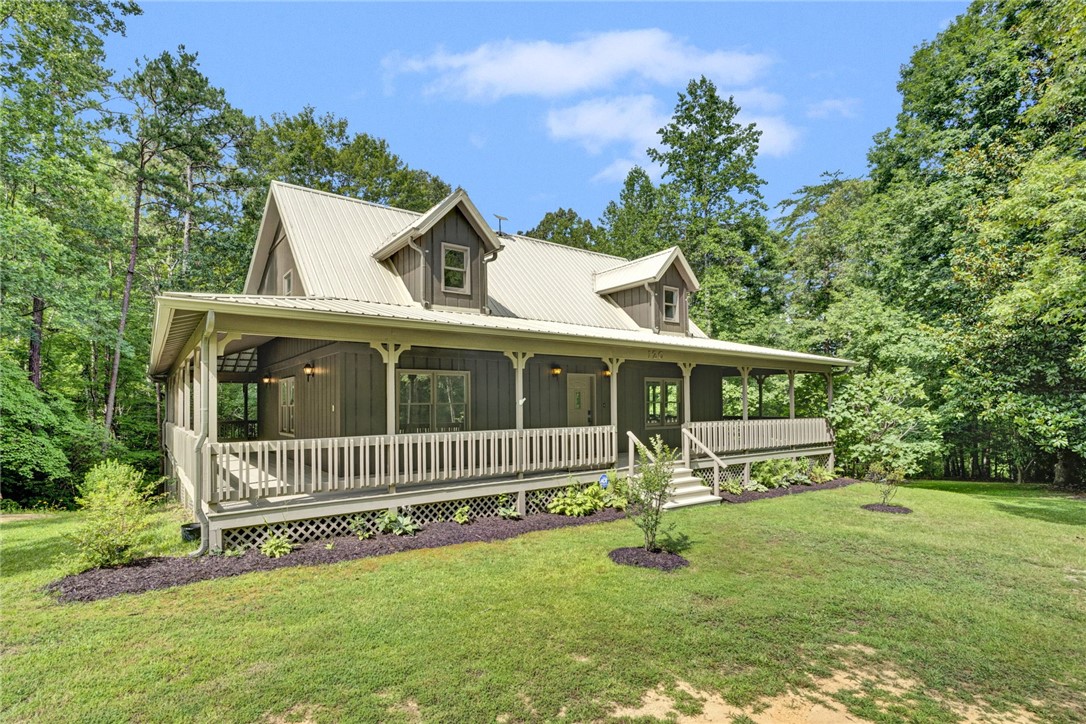 120 Patterson Ridge Road Salem, SC 29676 - Photo 2 of 46 A charming rustic dwelling featuring an expansive front porch, set against a backdrop of mature trees.