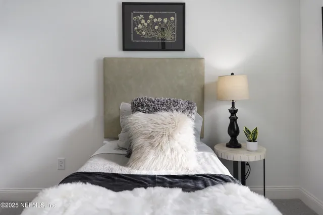 a bed sitting in a bedroom next to a window