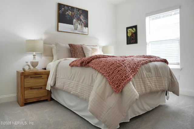 a large bed sitting in a bedroom next to a lamp