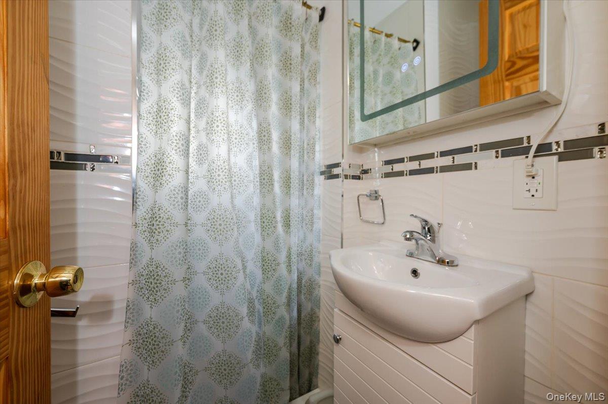 116-22 127th Street Queens, NY 11420 - Photo 11 of 18 a bathroom with a sink and mirror
