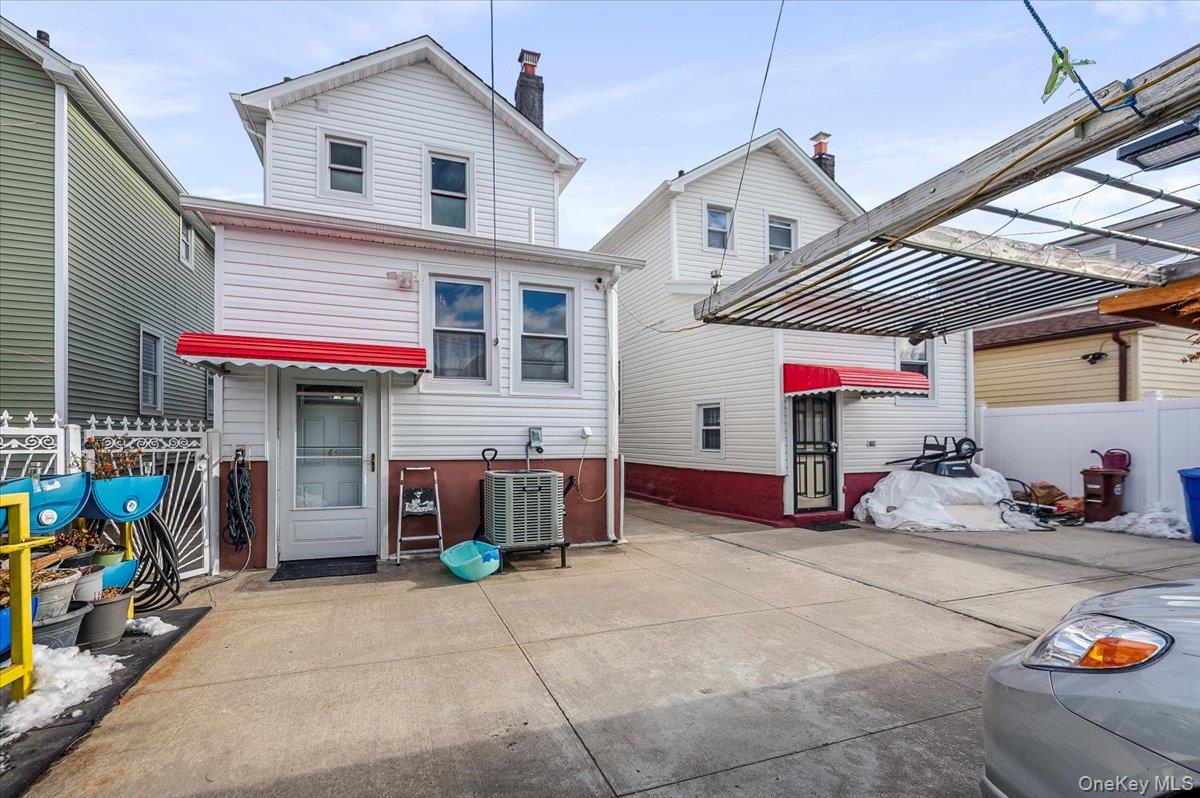 116-22 127th Street Queens, NY 11420 - Photo 16 of 18 a view of a house with a patio and a garage