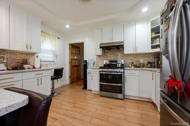 a kitchen with granite countertop a refrigerator stove top oven and sink