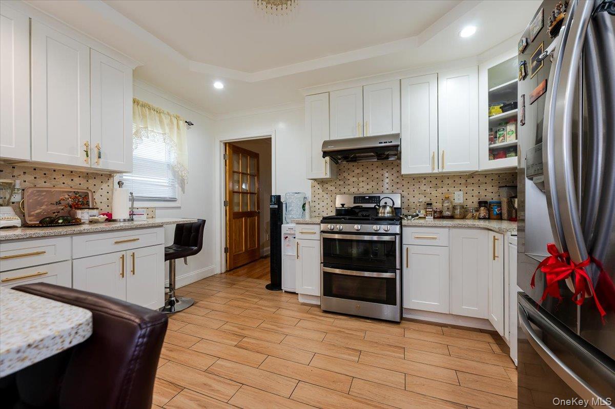 116-22 127th Street Queens, NY 11420 - Photo 6 of 18 a kitchen with granite countertop a refrigerator stove top oven and sink