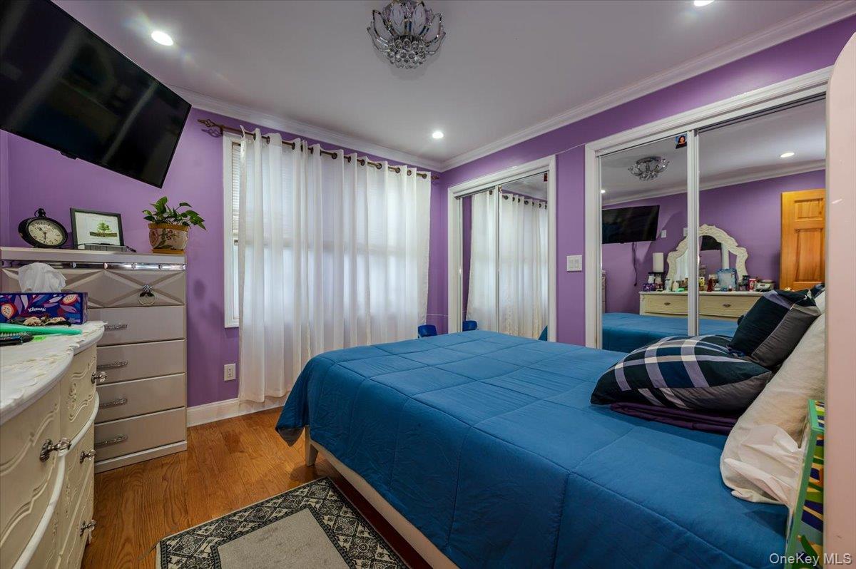 116-22 127th Street Queens, NY 11420 - Photo 9 of 18 a bedroom with a bed and a mirror