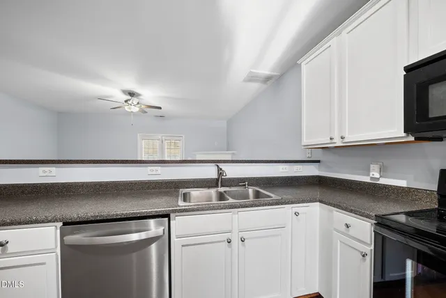 a kitchen with stainless steel appliances granite countertop a sink a stove microwave and cabinets