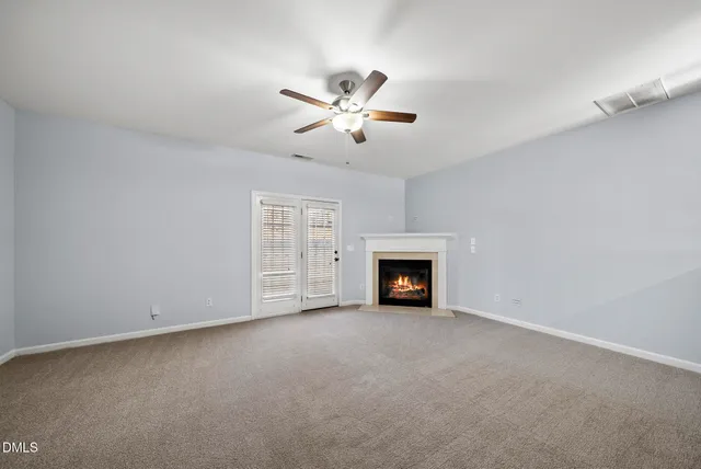an empty room with fireplace and fan