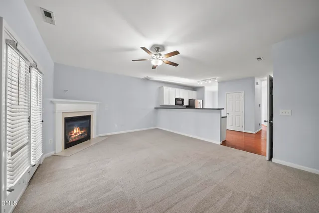 a view of a livingroom with a fireplace and a ceiling fan