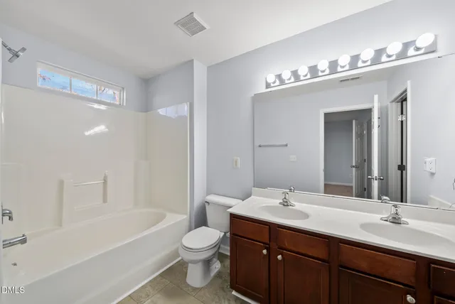 a bathroom with a sink a toilet a mirror and bathtub