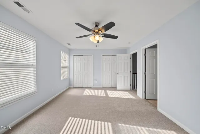a view of a livingroom with a ceiling fan and window