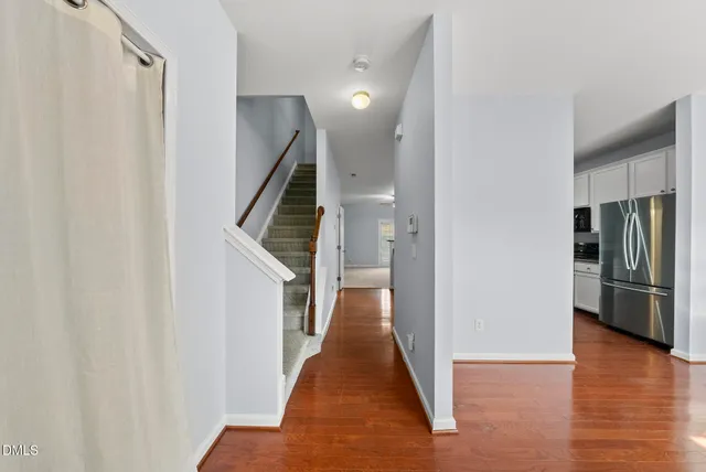 a view of a hallway with wooden floor and staircase