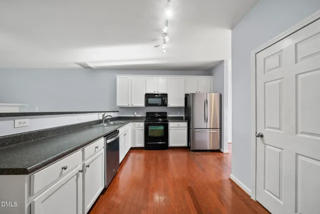 a kitchen with granite countertop a refrigerator and a sink