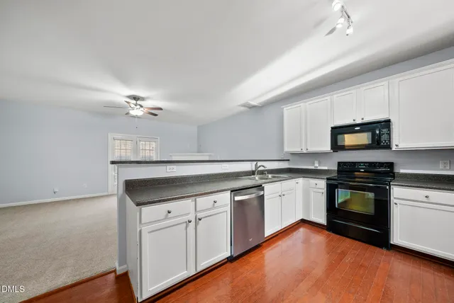 a kitchen with granite countertop white cabinets and stainless steel appliances