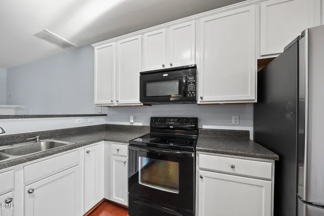 a kitchen with granite countertop white cabinets and stainless steel appliances