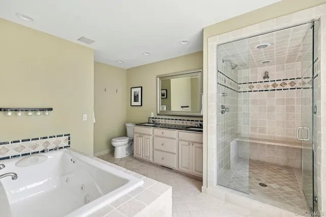 a bathroom with a tub sink mirror and toilet