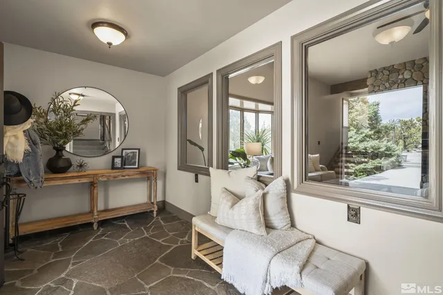 a living room with furniture a large window and wooden floor