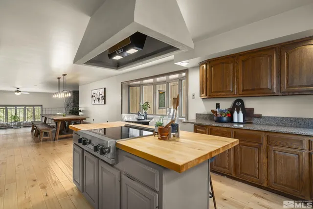 a kitchen with stainless steel appliances granite countertop a sink a stove and a wooden floors
