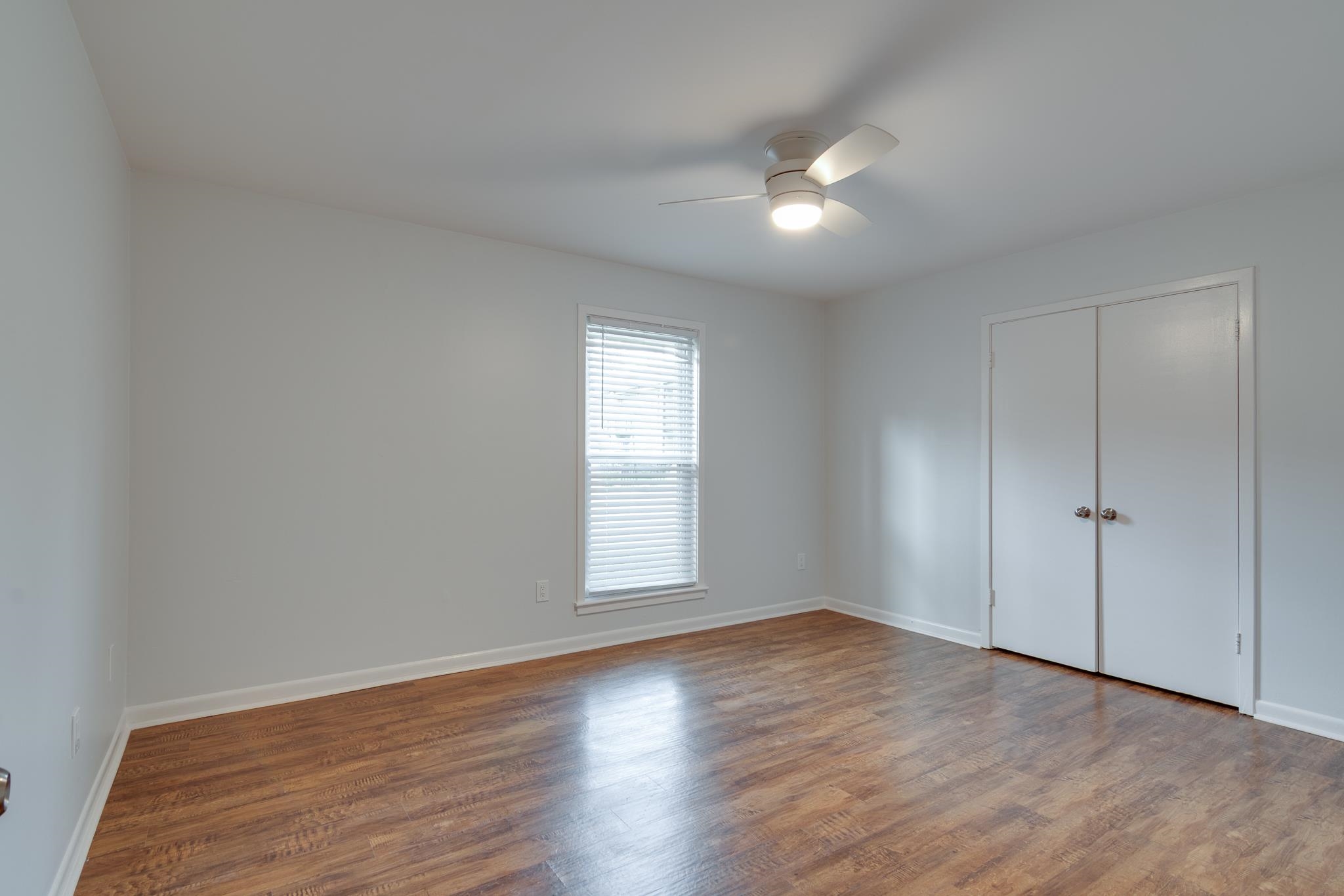971 June Road, Unit 7 Memphis, TN 38119 - Photo 10 of 23 Unfurnished bedroom featuring baseboards, a closet, wood finished floors, and ceiling fan