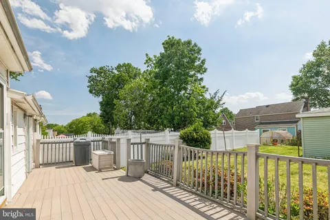 a view of a deck with barbeque grill and floor to ceiling window