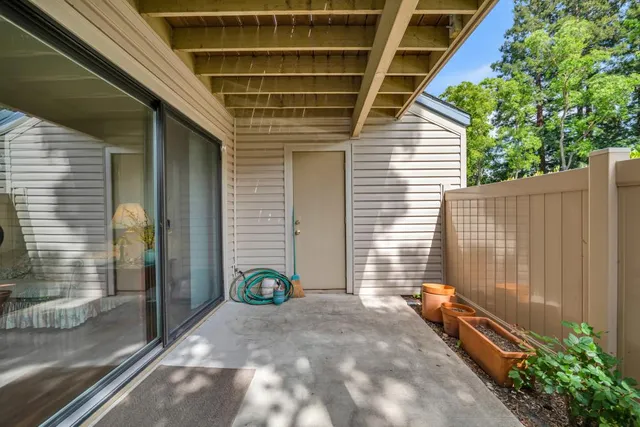 a view of backyard with a tub and wooden fence