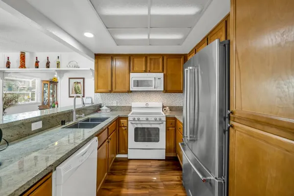a kitchen with granite countertop a sink and a refrigerator