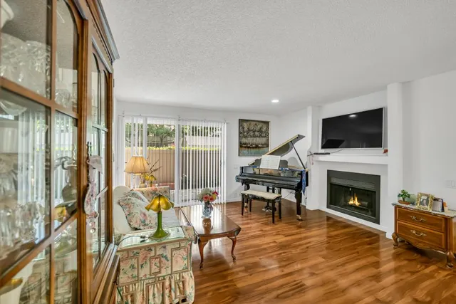 a living room with furniture a fireplace and a flat screen tv