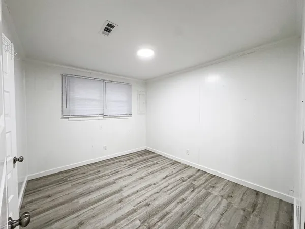 a view of empty room with wooden floor