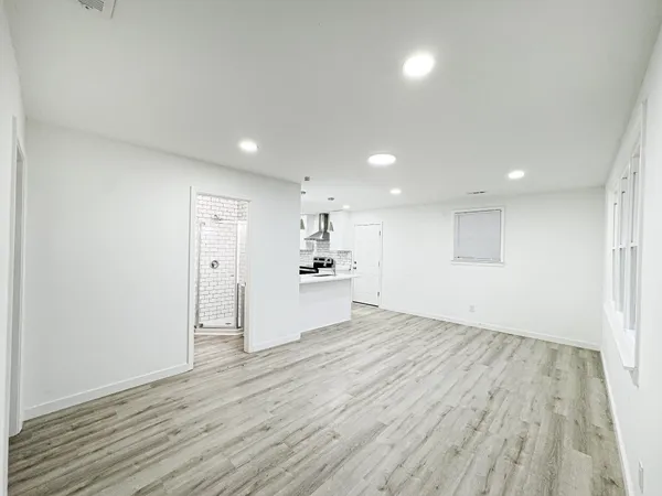 a view of a big room with wooden floor and windows