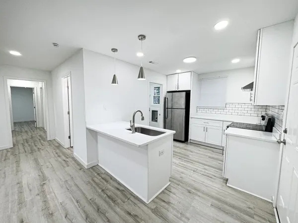 a kitchen with white cabinets and stainless steel appliances