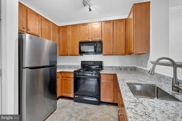 a kitchen with stainless steel appliances granite countertop a refrigerator a stove a sink and dishwasher