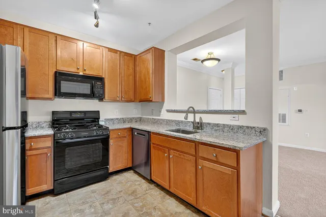 a kitchen with stainless steel appliances granite countertop wooden cabinets stove a sink and dishwasher
