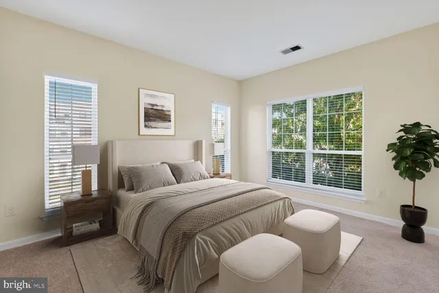 a bedroom with a bed and a large window