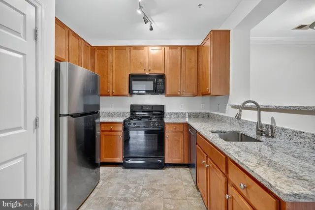 a kitchen with stainless steel appliances granite countertop a refrigerator stove and sink