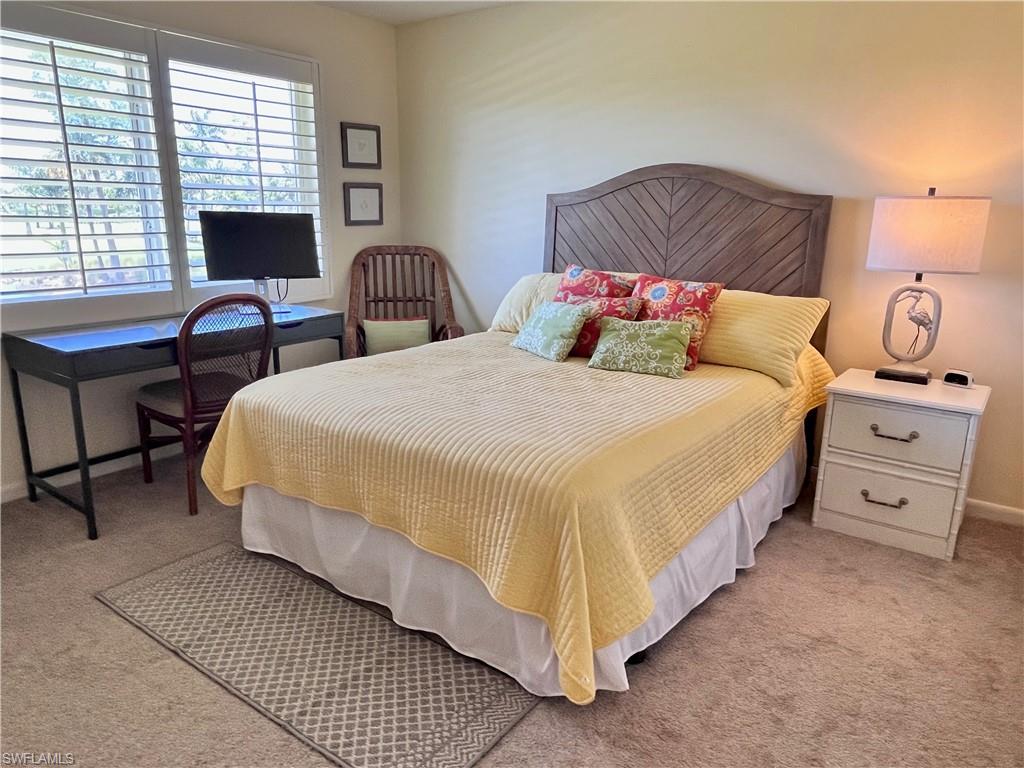 201 Albi Road, Unit 2 Naples, FL 34112 - Photo 14 of 31 Queen size bed with golf course views with a desk and recliner and dresser,