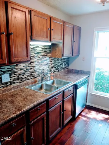 a kitchen with stainless steel appliances granite countertop a sink a stove and a wooden cabinets