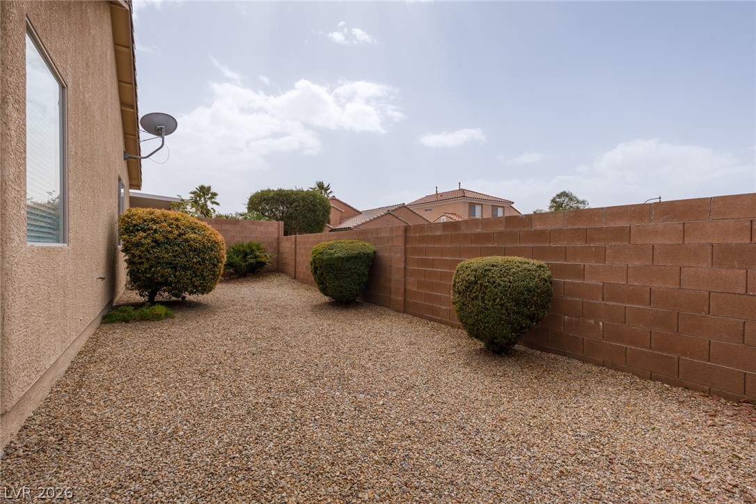 787 Rise Canyon Drive Henderson, NV 89052 - Photo 18 of 22 A private xeriscaped yard bordered by a sturdy brick privacy wall offers low-maintenance outdoor living.