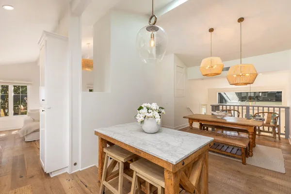a kitchen with a table a stove and wooden floor