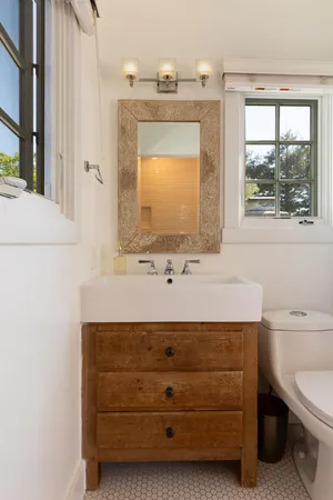 a bathroom with a sink a toilet and mirror