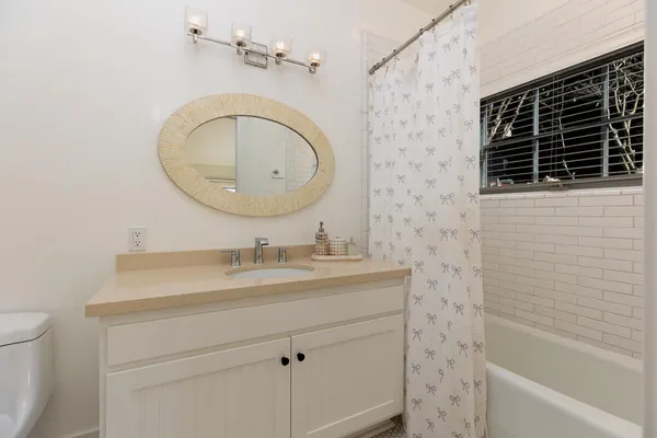 a bathroom with a sink a mirror a toilet and bathtub