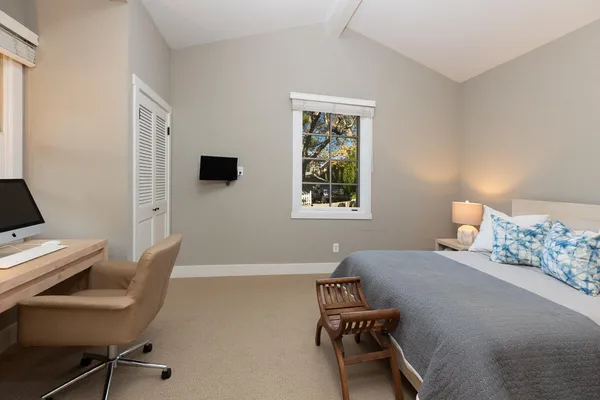 a bedroom with a bed and a desk