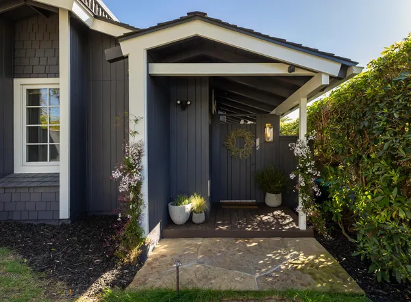 a view of a porch with a table and chairs and potted plants
