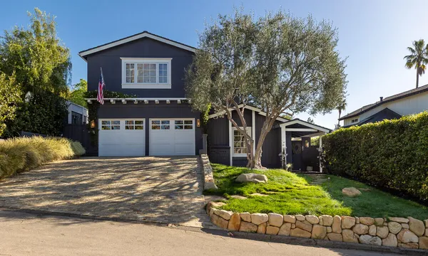 a front view of a house with a yard and outdoor seating