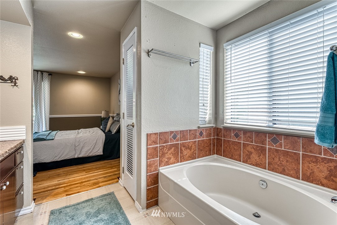 7025 Vandermark Road East Bonney Lake, WA 98391 - Photo 14 of 25 a bathroom with a tub and a large window