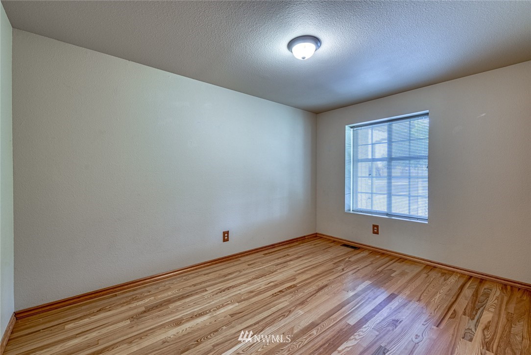 7025 Vandermark Road East Bonney Lake, WA 98391 - Photo 16 of 25 wooden floor in an empty room with a window